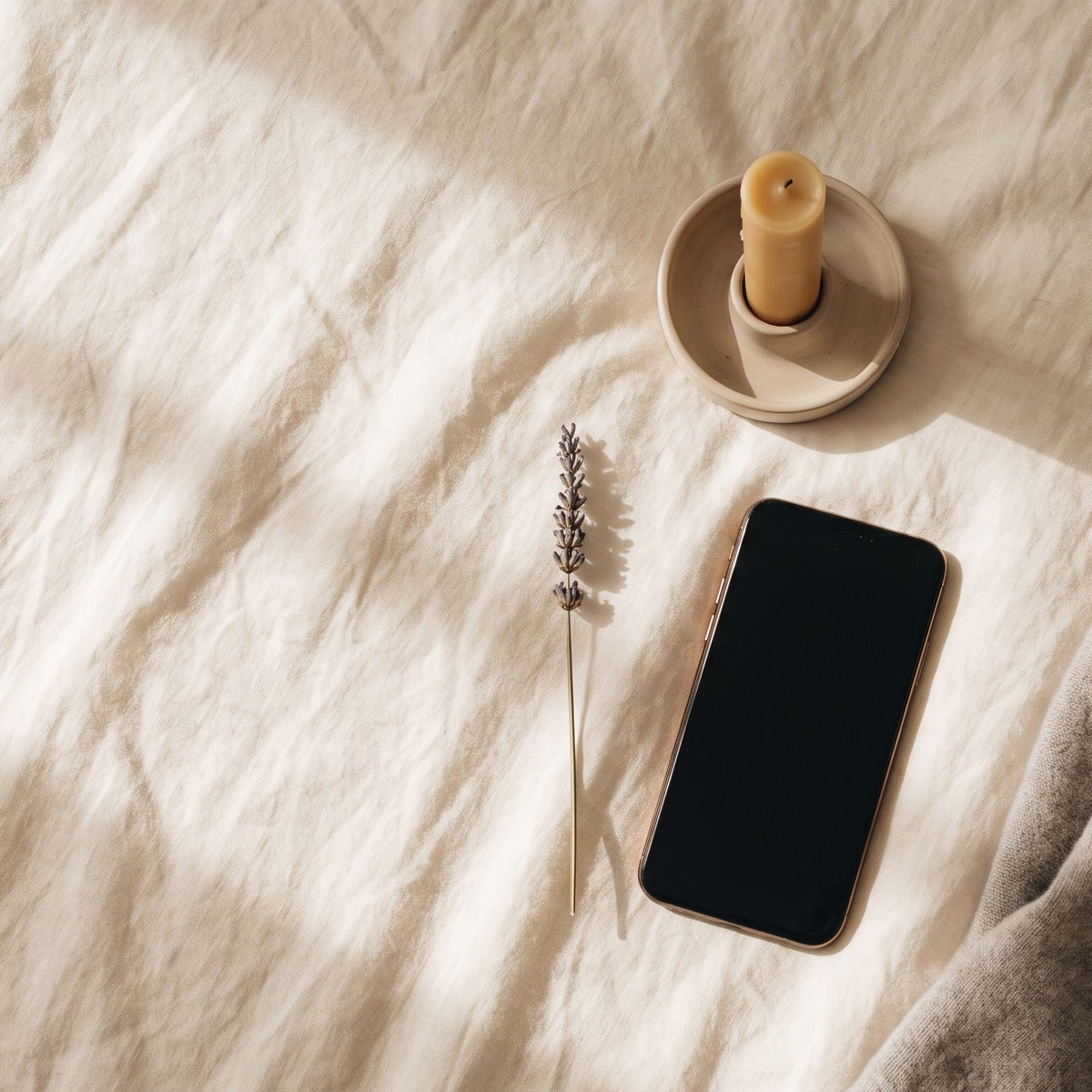 Téléphone, bougie et lavande sur du lin : le rituel du soir